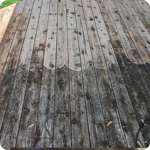 A wooden deck in the process of being cleaned, with a clear distinction between the dirty and cleaned wood planks.