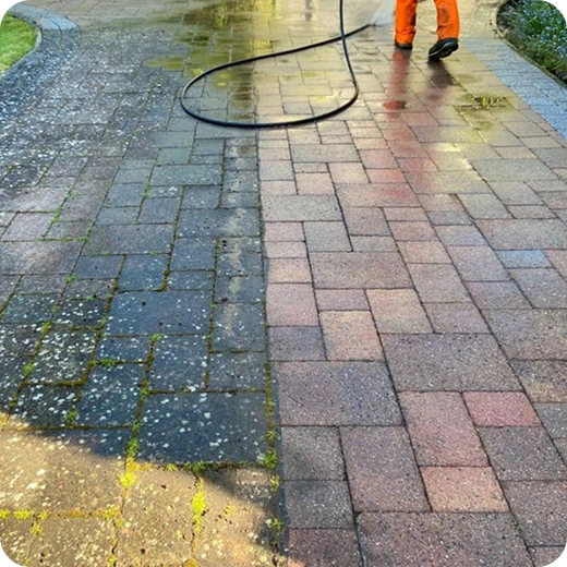 Before-and-after view of a stone paver walkway being pressure washed, showing the removal of moss and dirt.
