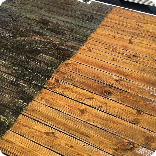A before-and-after view of a wood deck cleaning, showing the contrast between the dirty and clean sections.