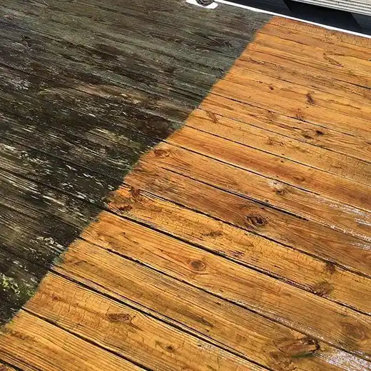A before-and-after view of a wood deck cleaning, showing the contrast between the dirty and clean sections.
